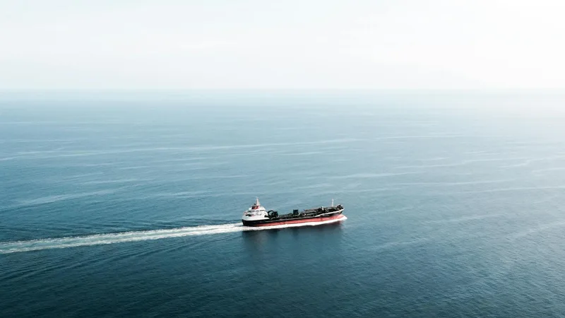 Barco portacontenedores en alta mar en ruta marítima Colombia a USA con cielo al atardecer