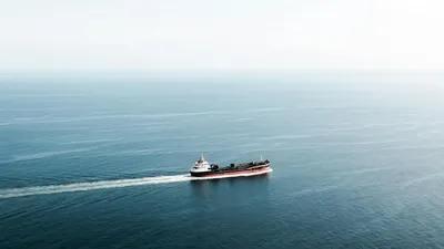 Barco portacontenedores en alta mar en ruta marítima Colombia a USA con cielo al atardecer